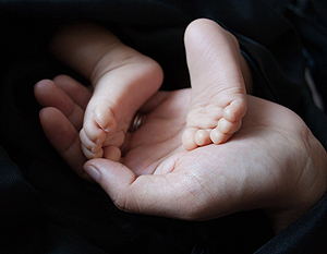 a hand holding a baby's feet