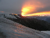 On summit day, the Sun shoots out of the East, cast under the clouds.