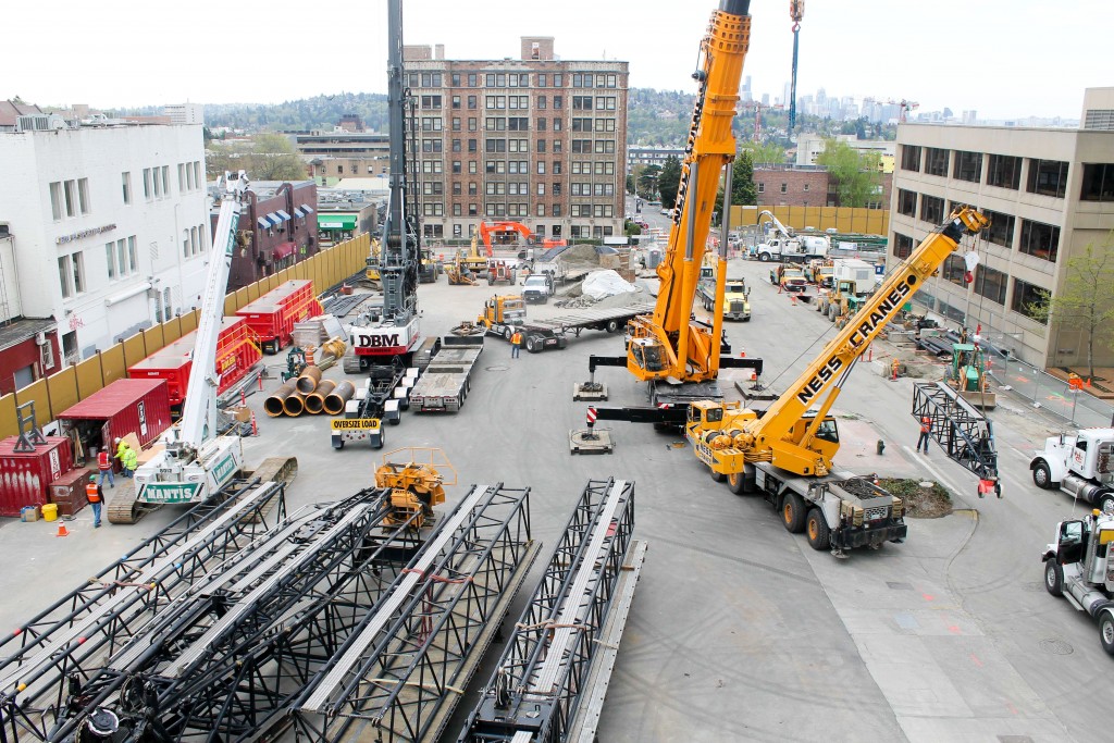 A smaller crane is assembling the large crane.