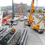 A smaller crane is assembling the large crane.