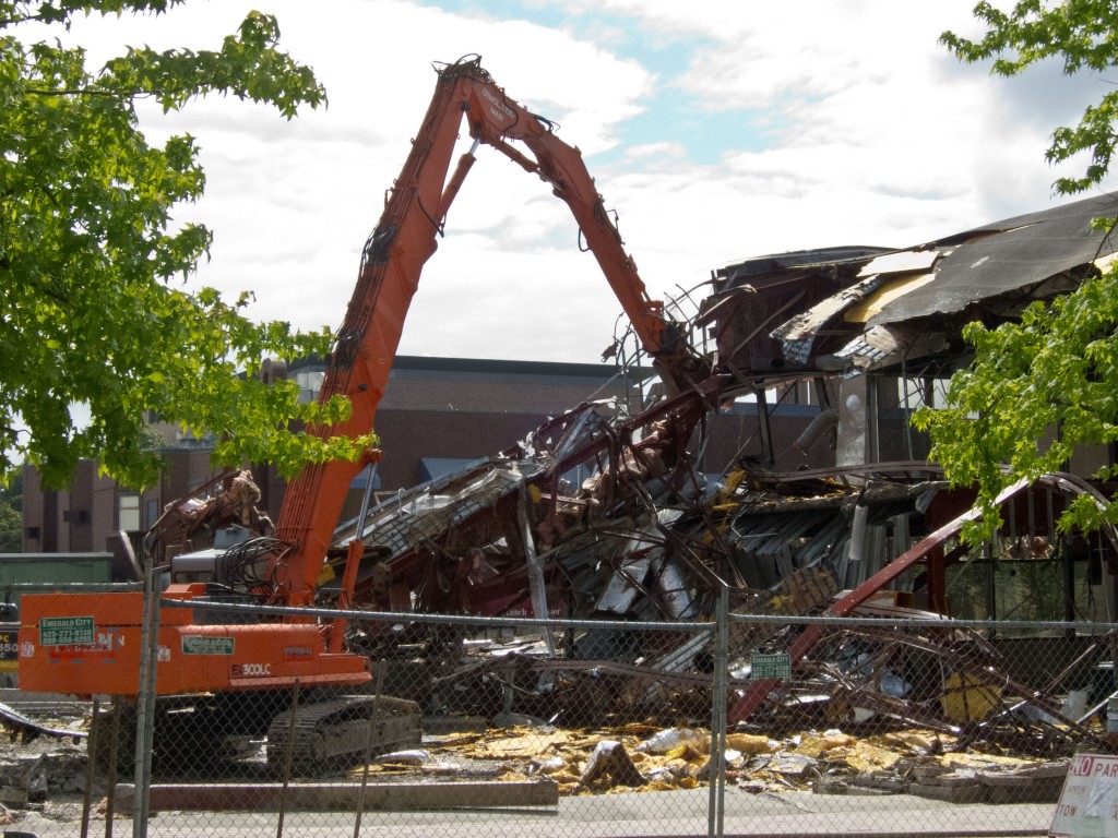 A long-armed excavator with a "nibbler" attachment severs steel beams like they were paper.