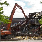 A long-armed excavator with a "nibbler" attachment severs steel beams like they were paper.