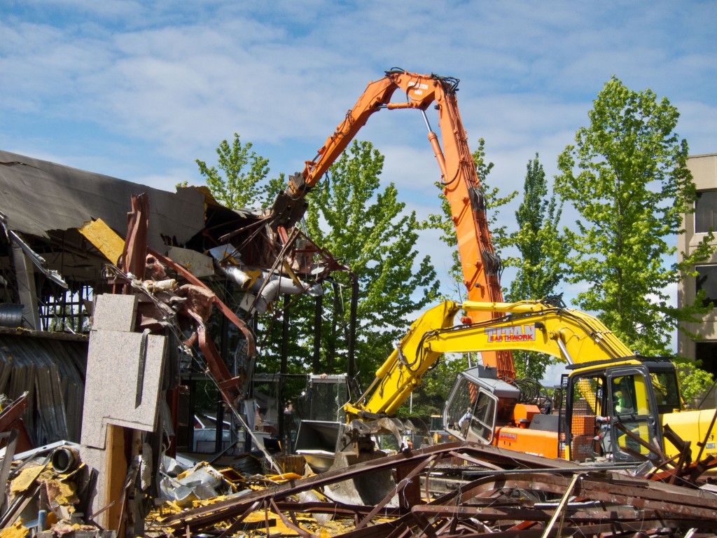 A second excavator takes the refuse and neatly stacks it into recyclable and non-recyclable piles.