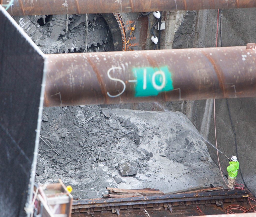 A worker spraying water to keep the dust down.