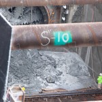 A worker spraying water to keep the dust down.